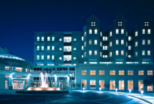 Exterior photo of Wolfson Children's Hospital at night. Blue lights and fountain surrounded by brick circle drive.